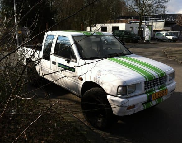 Witte bedrijfswagen met groene zijstriping over de flank en deuren