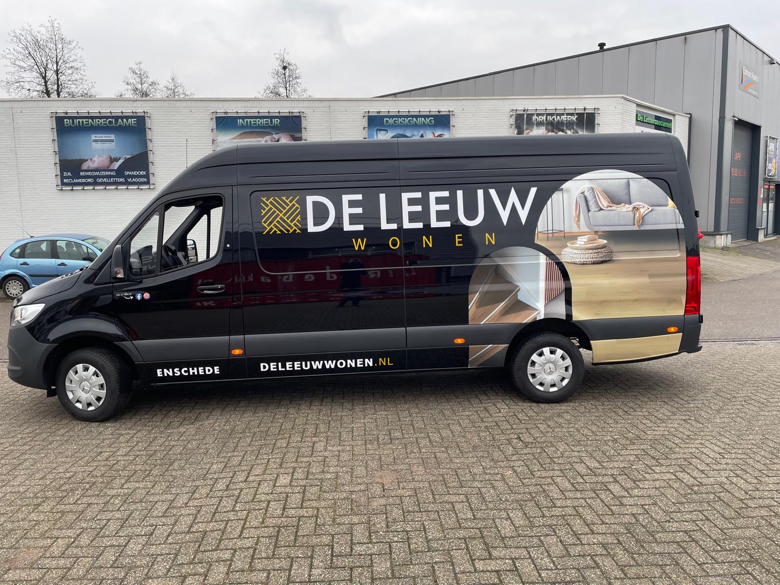 Autoreclame voor De Leeuw Wonen op een bestelbus